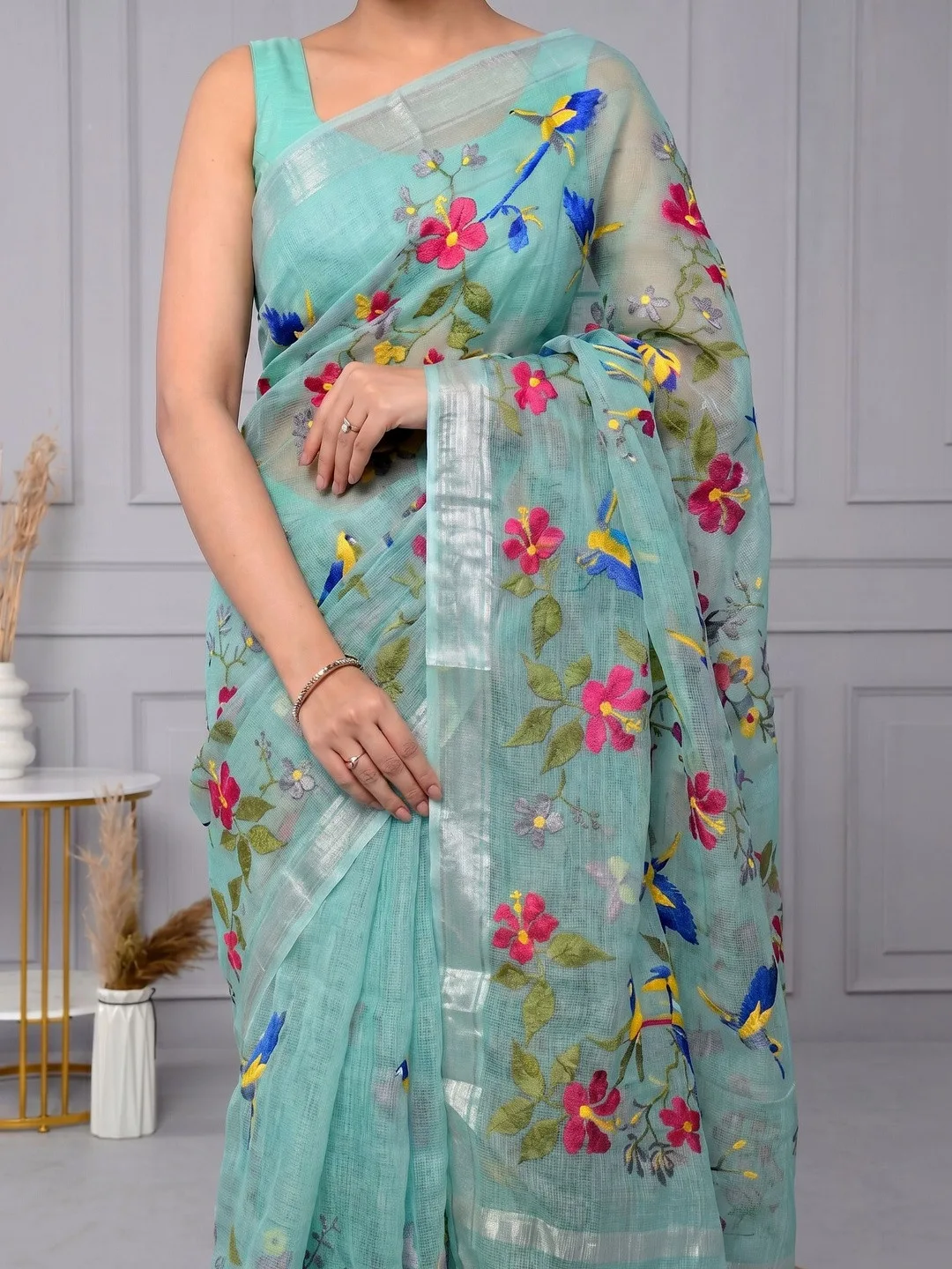 Floral embroidery and woven-design border on sea green Kota Doria — detail